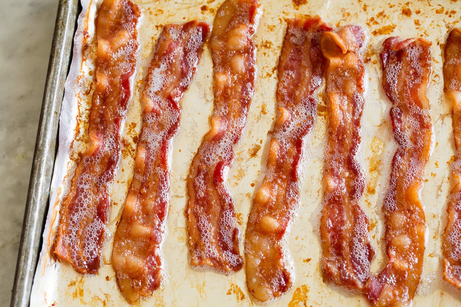 Cooked bacon on a baking sheet.