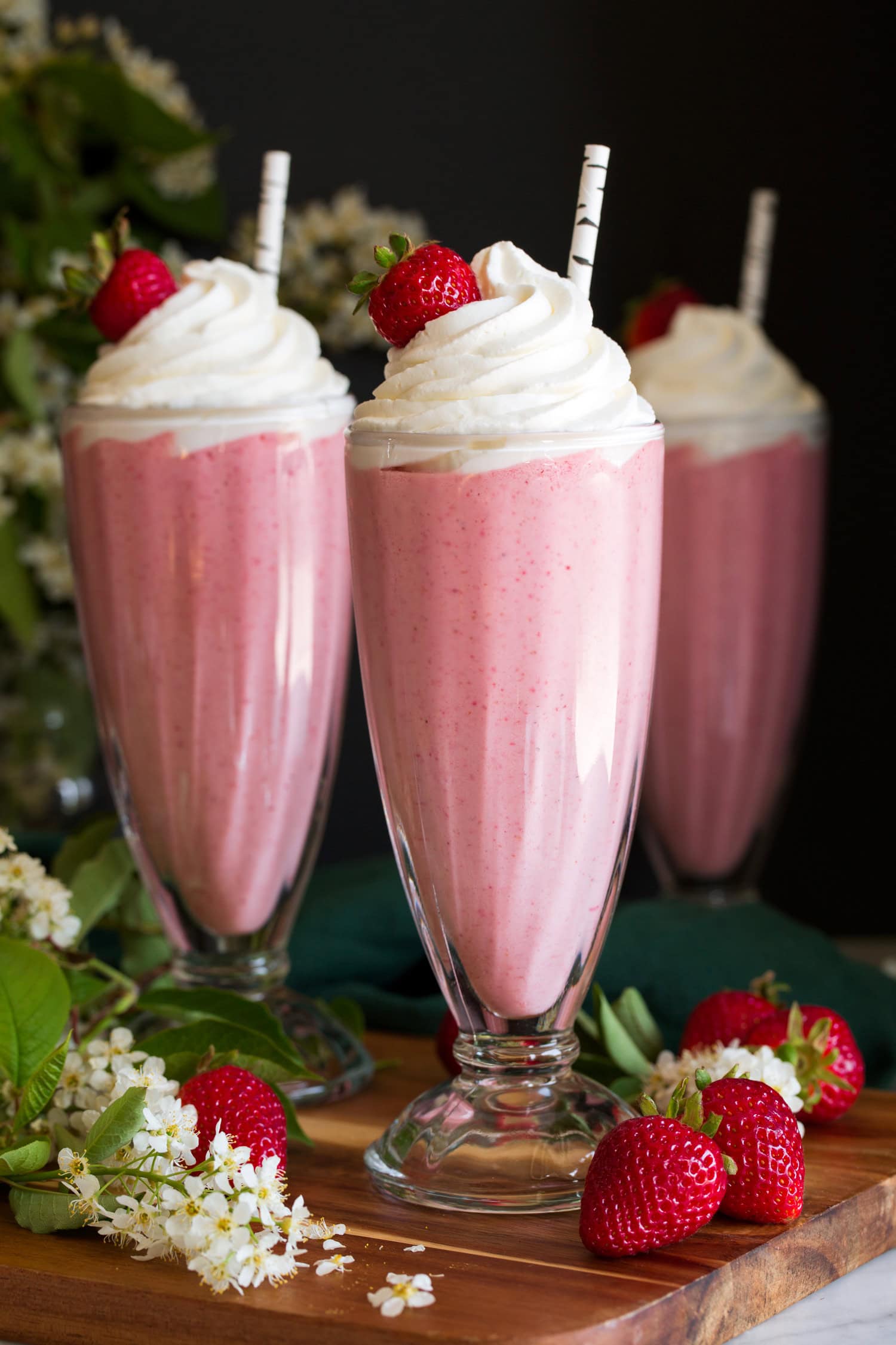 Close up photo of three strawberry milkshakes.