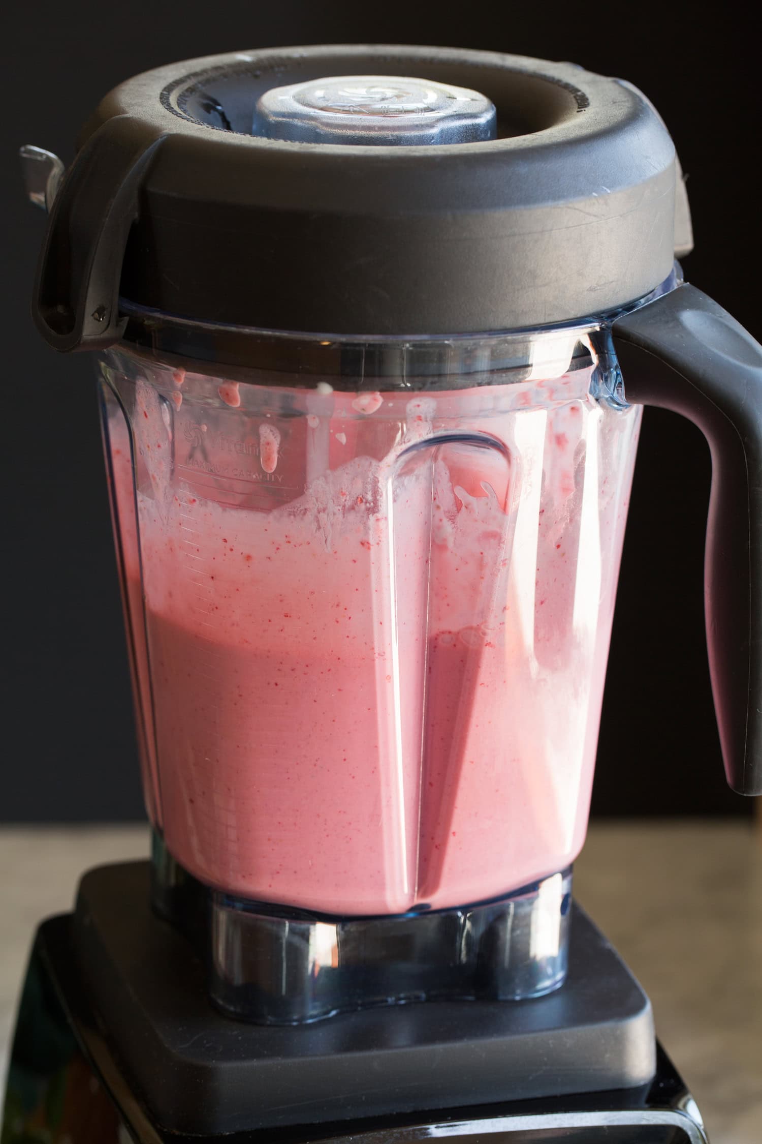 Blended strawberry milkshake in a blender.