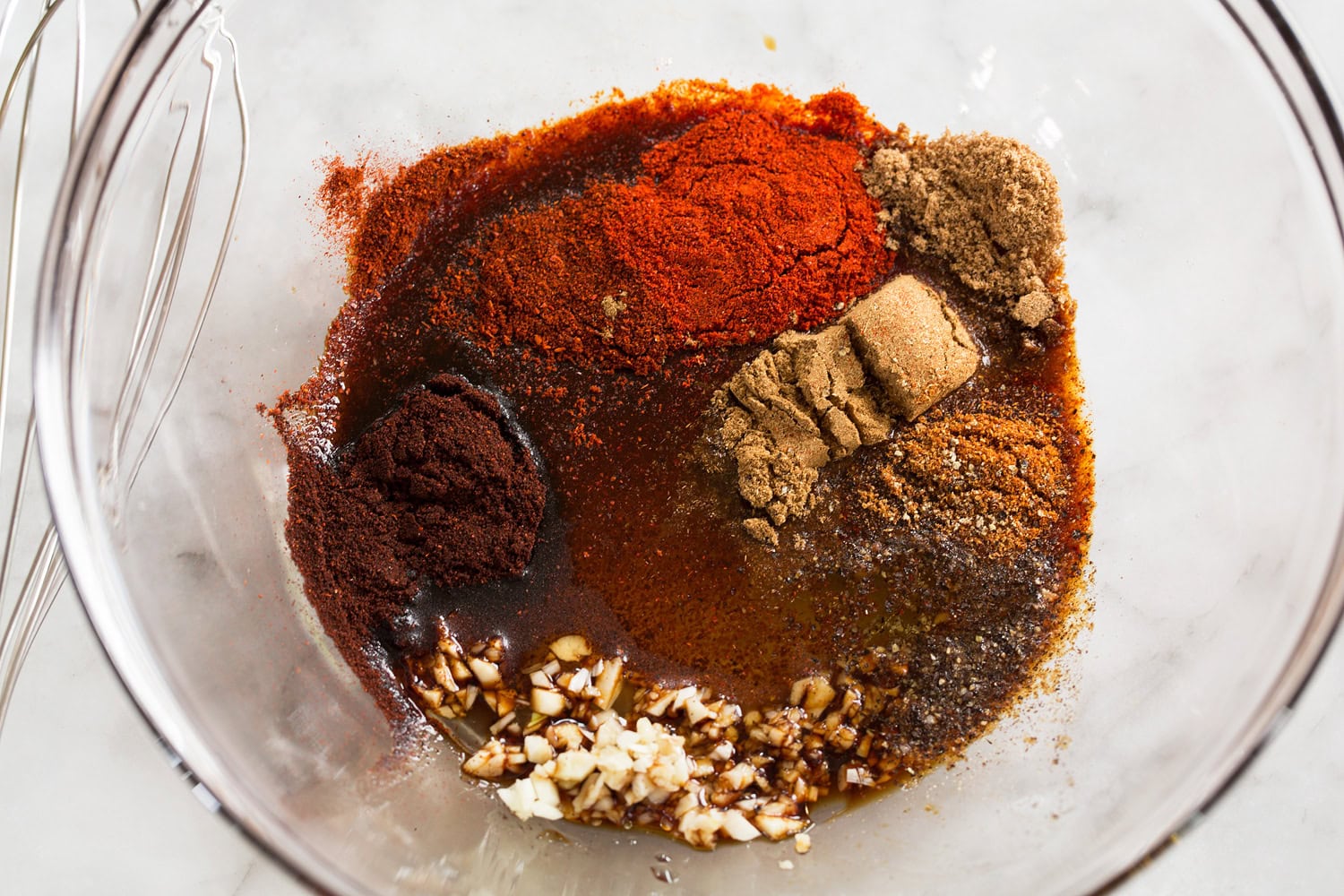Mixing spice seasoning in a glass mixing bowl.